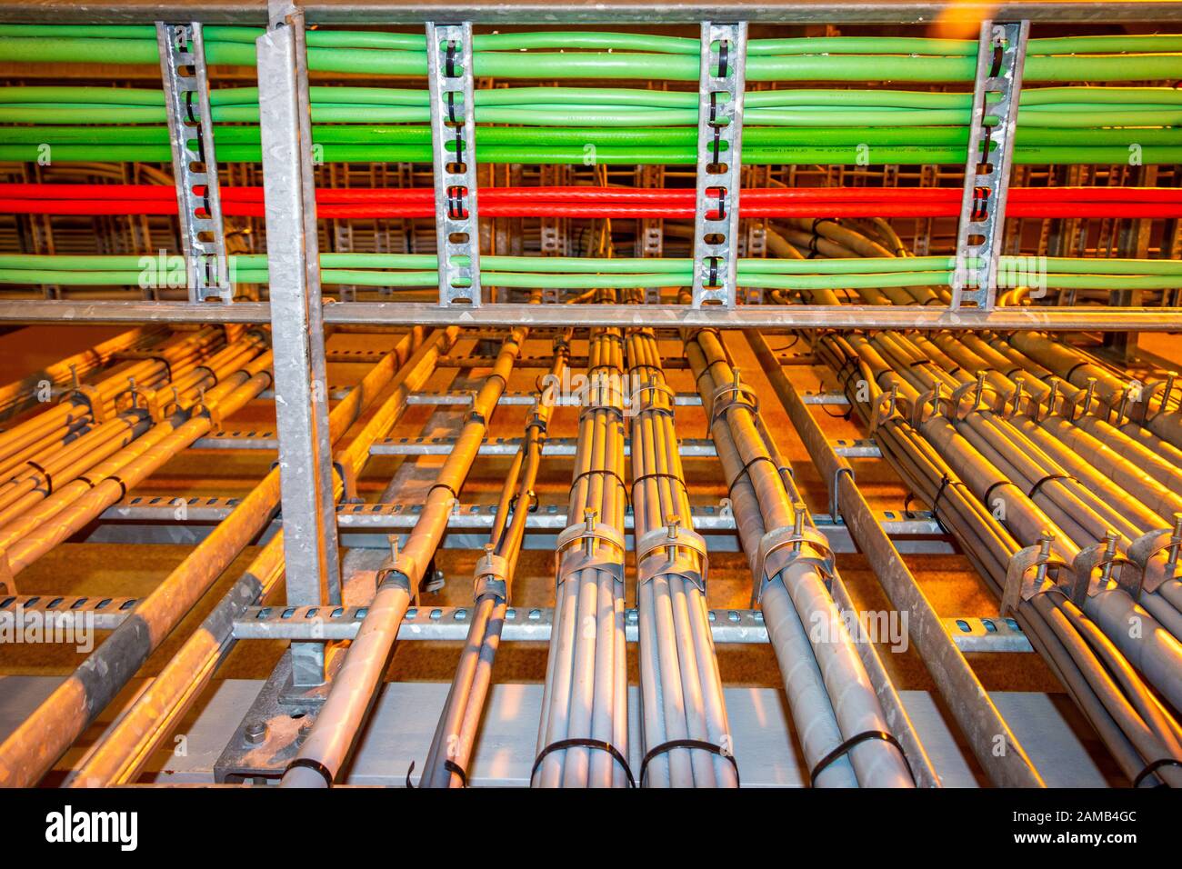 Electrical grey cables mounted in a rack for power supply in a industrial area Stock Photo