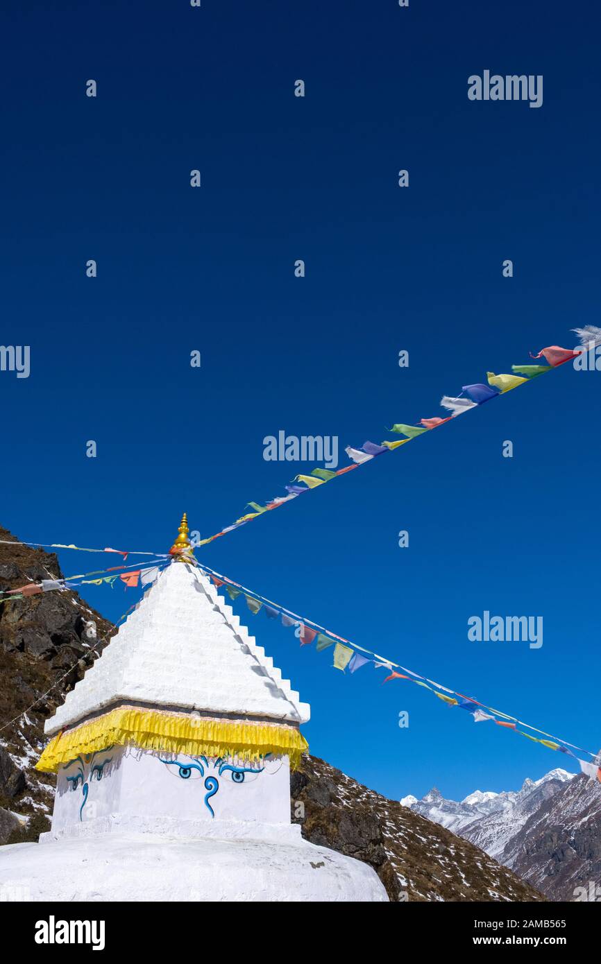 Buddhist Chorten / Stupa / shrine with prayer flags and all seeing eyes, Nepal Himalayas Stock Photo