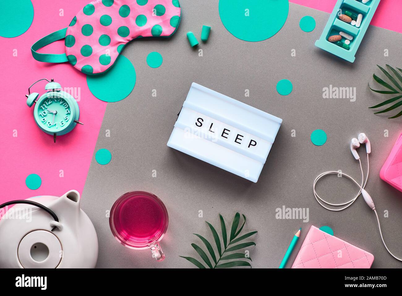 Sleeping mask, turquoise alarm, earphones and earplugs. Calming remedies - pills, capsules and tea. Sleep log notebook. Flat layout, two tone pink and Stock Photo