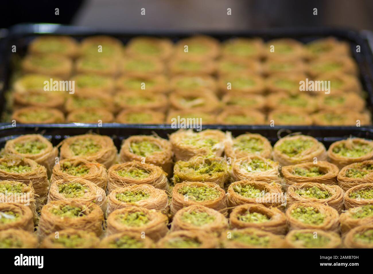 Baklava (modern Middle Eastern Arab-style dessert) baked with sugar and honey syrup, sweet and stuffed with almonds, nuts and pistachios. old city. Stock Photo