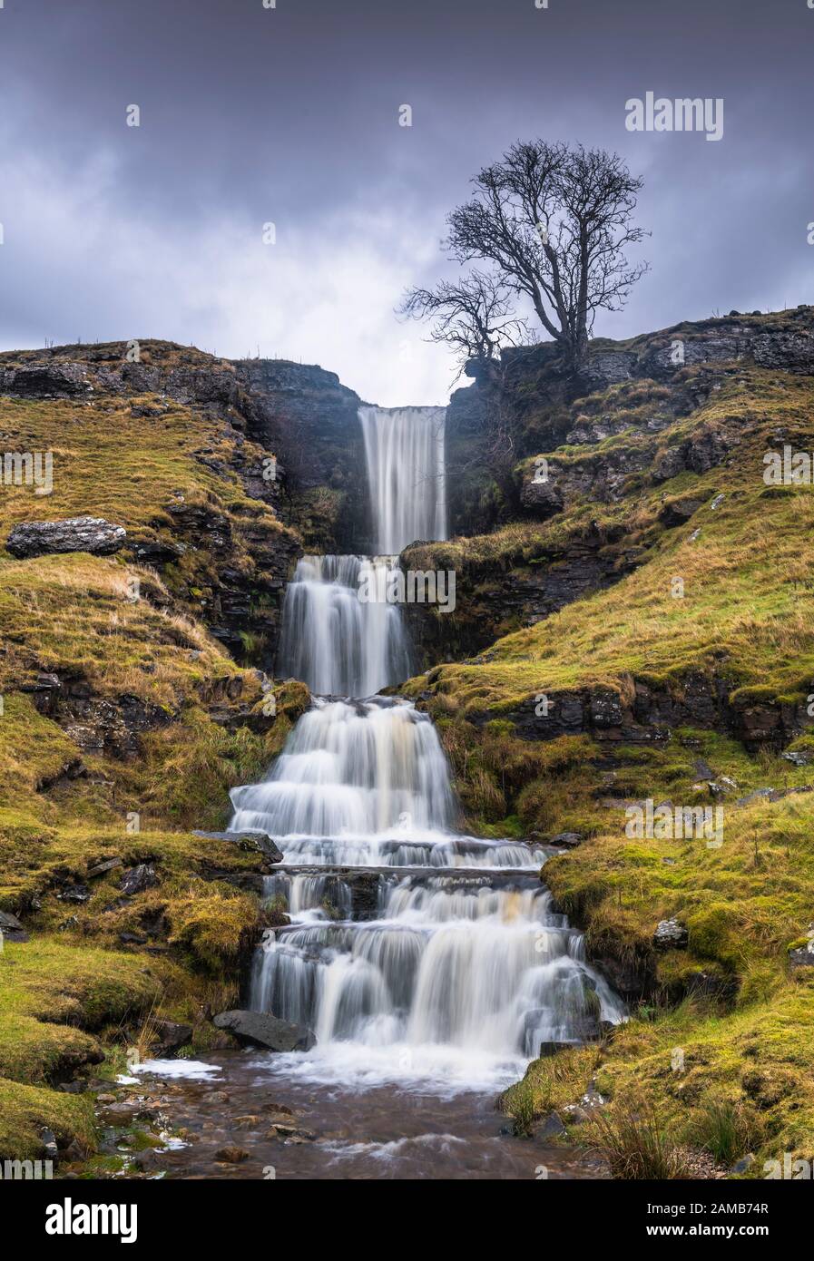 Standing in a rain & hail storm photographing the stunning cascading terraces of Cow Gill Waterfalls in Cray, Yorkshire Dales National Park. Stock Photo