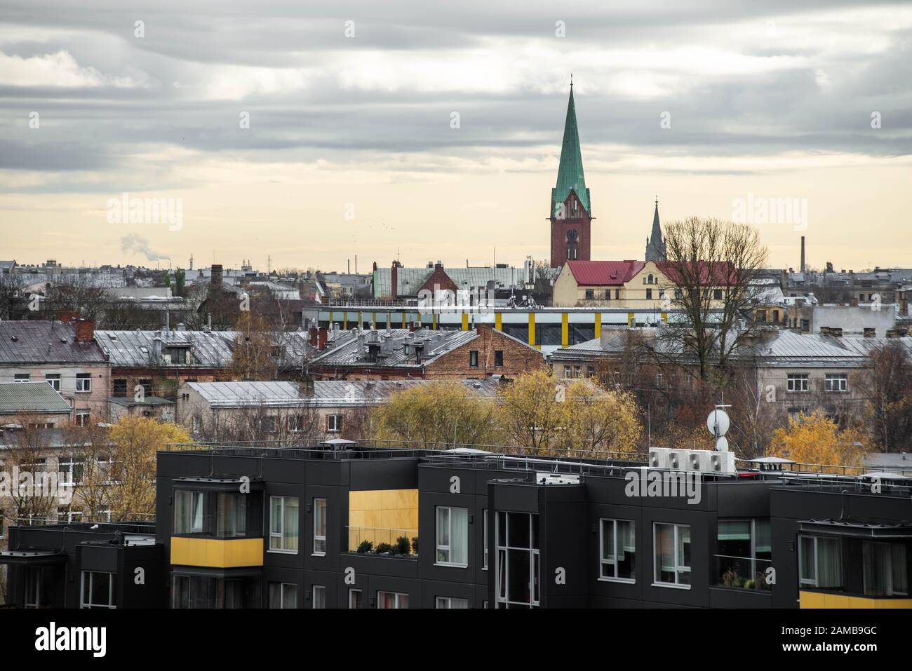 Cityscape in cloudy day. View of roofs. Catolic church bell tower. Stock Photo