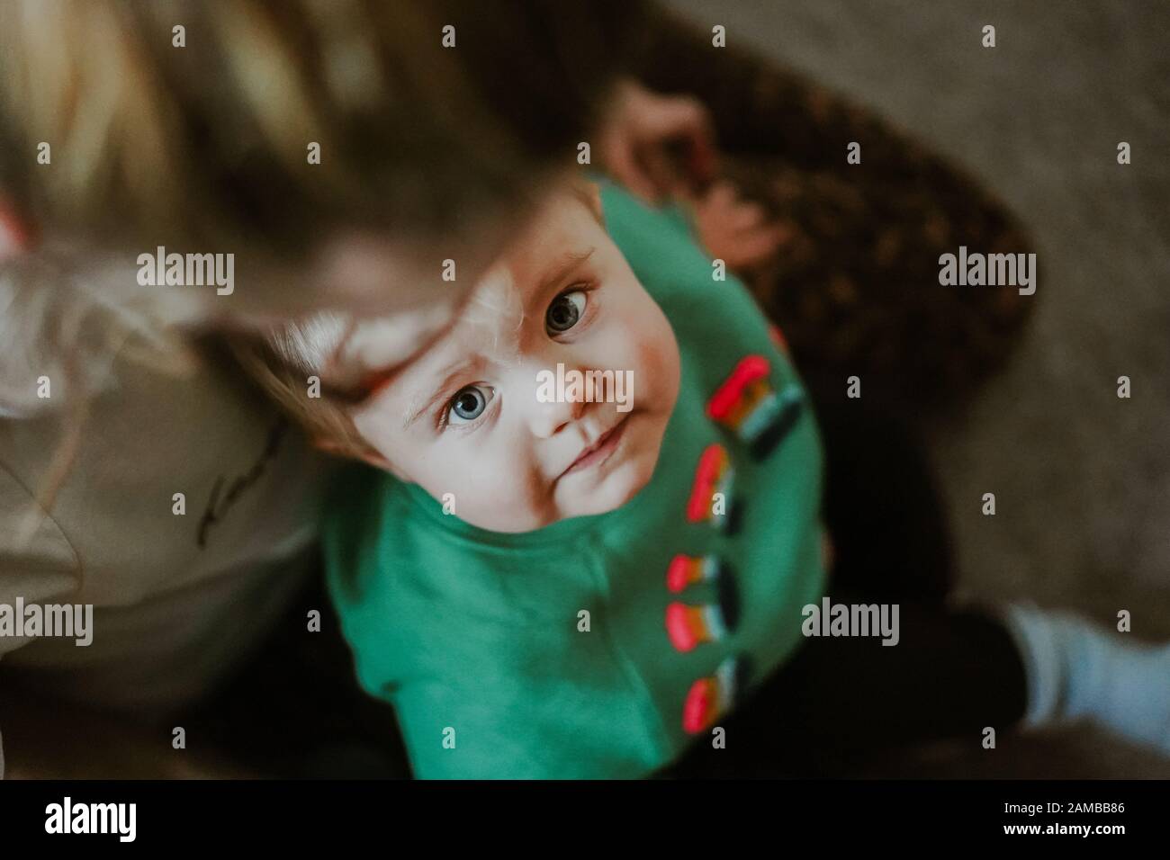 Young child sitting on mums lap Stock Photo