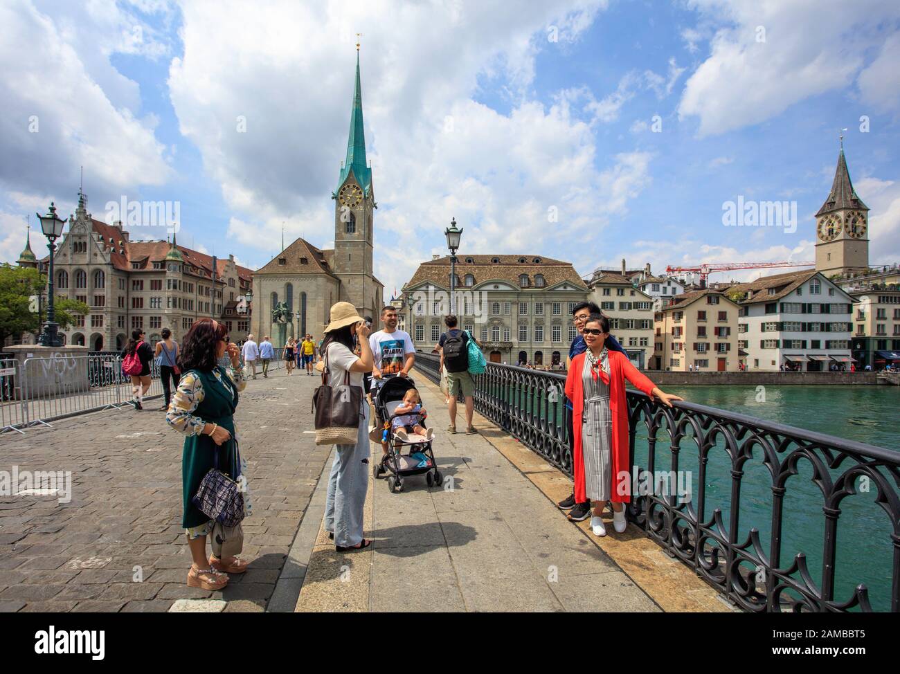 Tourist take a picture on Munsterbrucke bridge over Limmat river