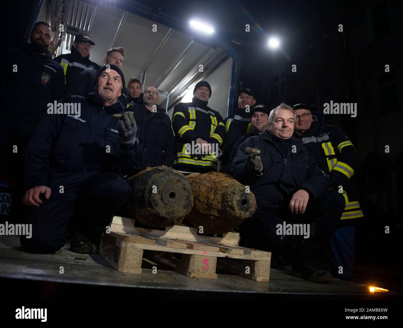 Dortmund, Germany. 12th Jan, 2020. Bomb disposal expert Karl-Friedrich Schröder (l) shows the detonator of one of two defused bombs from the Second World War on the loading area of a truck with his team. No unexploded ordnance had been detected at two other suspected sites. The aircraft bombs were located in a densely populated residential area. As a result, some 14 000 people had to leave their homes. Credit: Bernd Thissen/dpa/Alamy Live News Stock Photo
