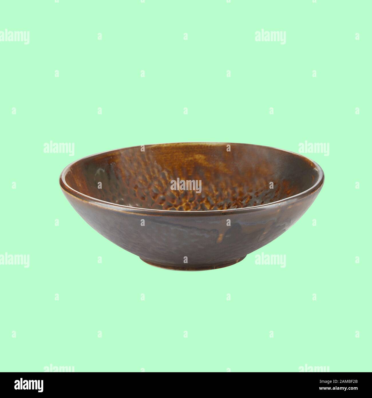 Ceramic bowl on green background with path. View from side Stock Photo