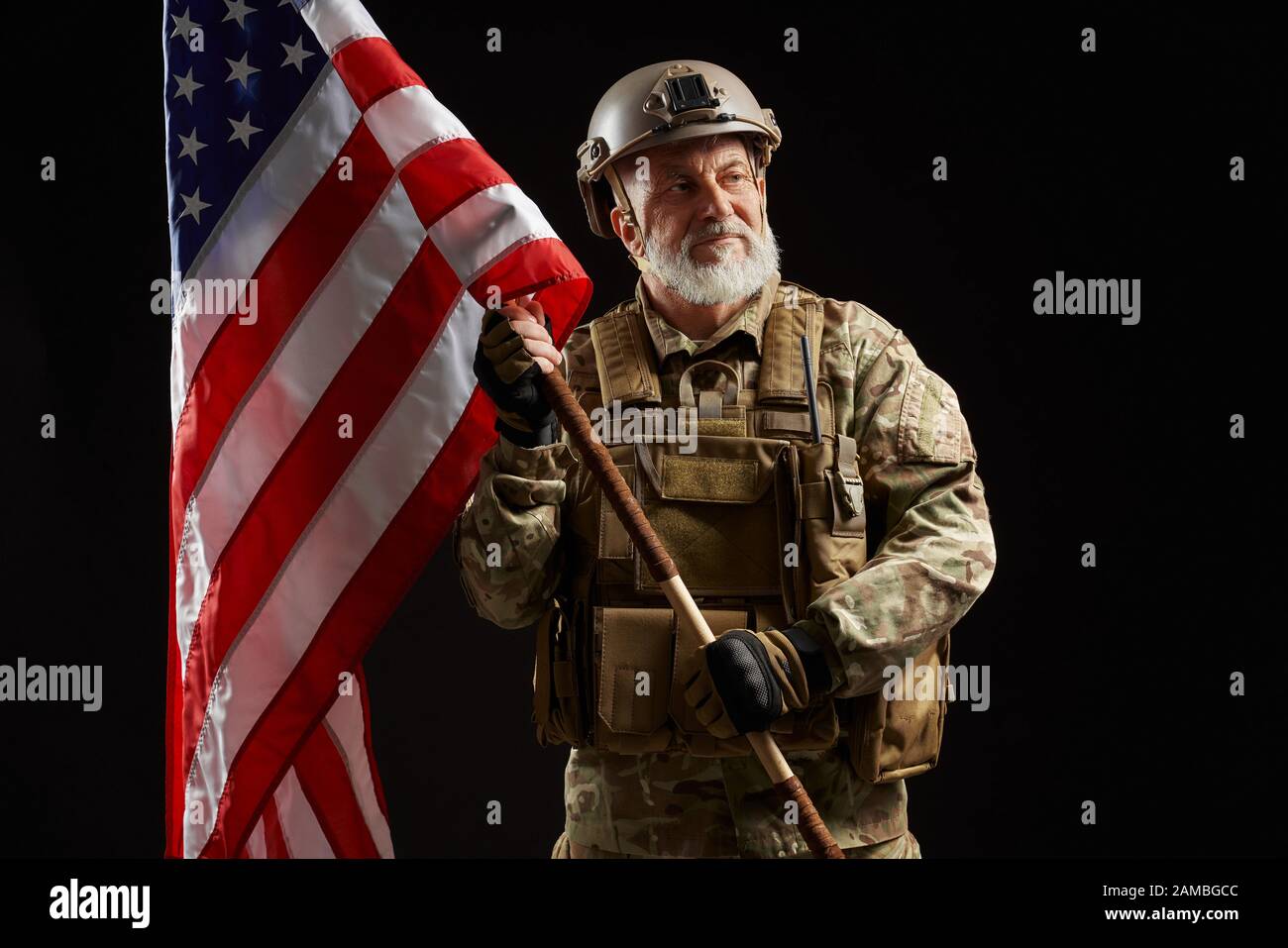 Front view of old military officer holding flag and looking away ...