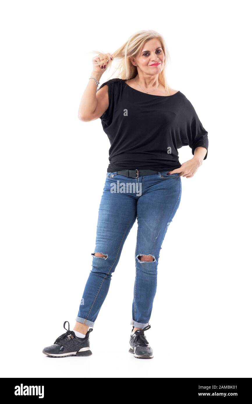 Doubtful pretty middle aged woman pulling and twisting blond hair looking at camera. Full body length isolated on white background. Stock Photo