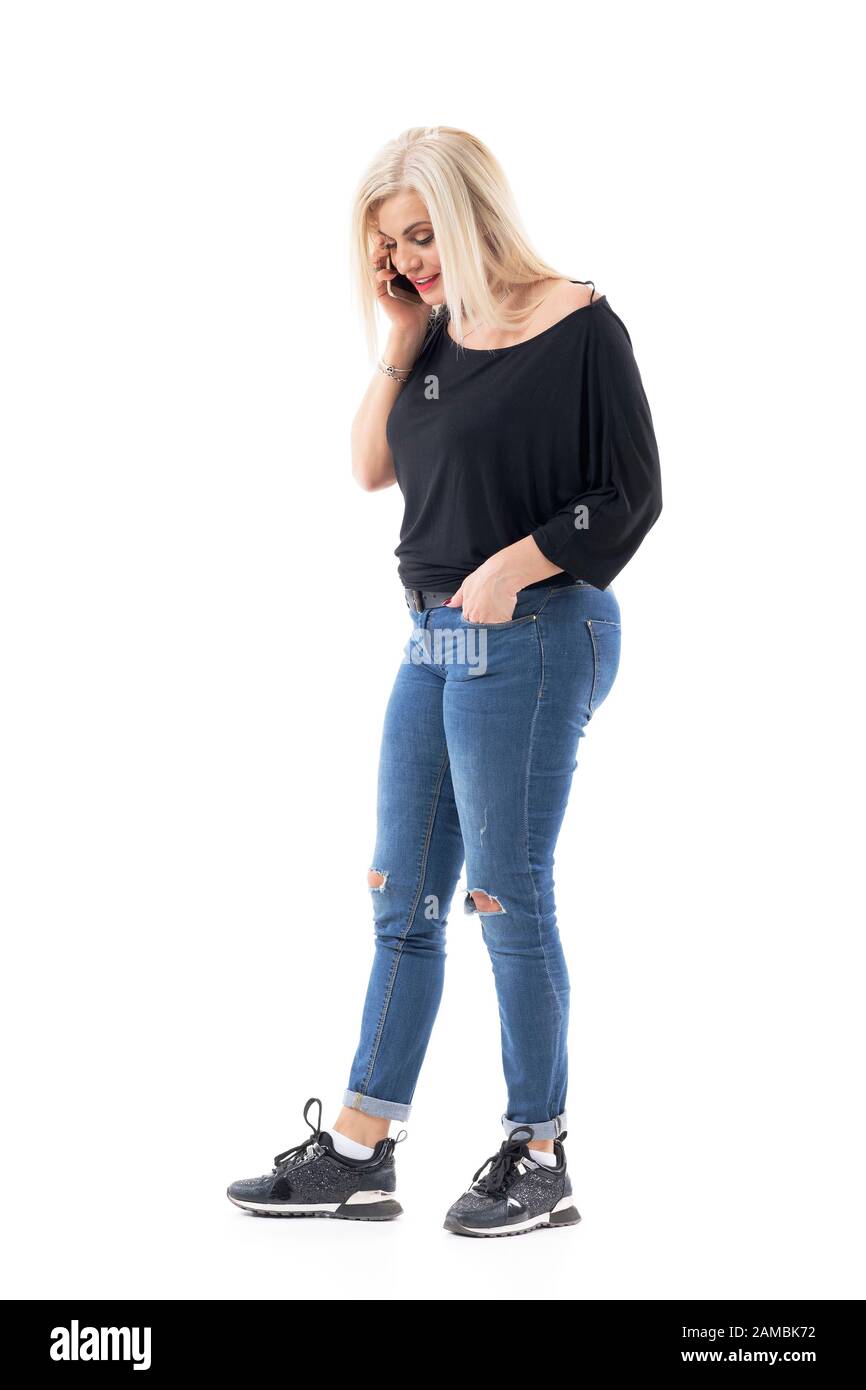 Cool modern casual middle age woman in jeans and sneakers relaxing and  talking on the cell phone. Full body length isolated on white background  Stock Photo - Alamy