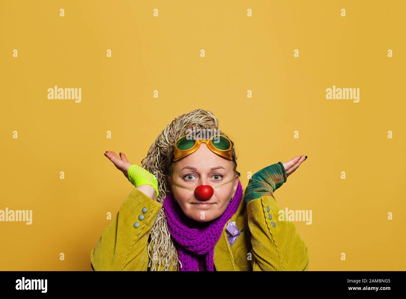 Female artist in clown costume on bright yellow background Stock Photo ...