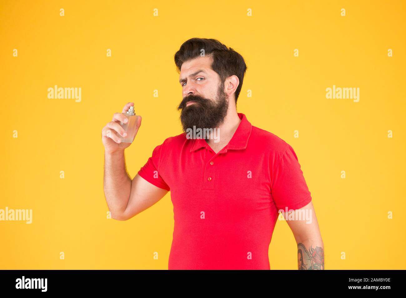 Perfumery products concept. Man well groomed bearded handsome hold bottle perfume. Wearing perfume. Choose perfume for men according occasion. Make sure smell fresh throughout day. Lotion and spray. Stock Photo