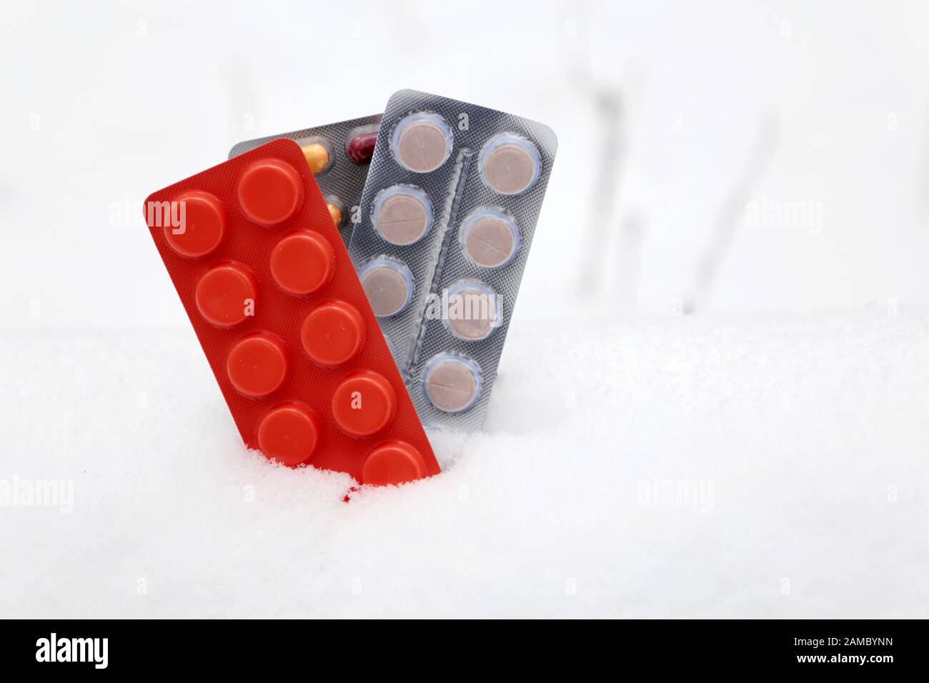 Pills in blister packs in the snow, different cooled medication close-up. Concept of pharmacy, vitamins in cold and flu season, health care in winter Stock Photo