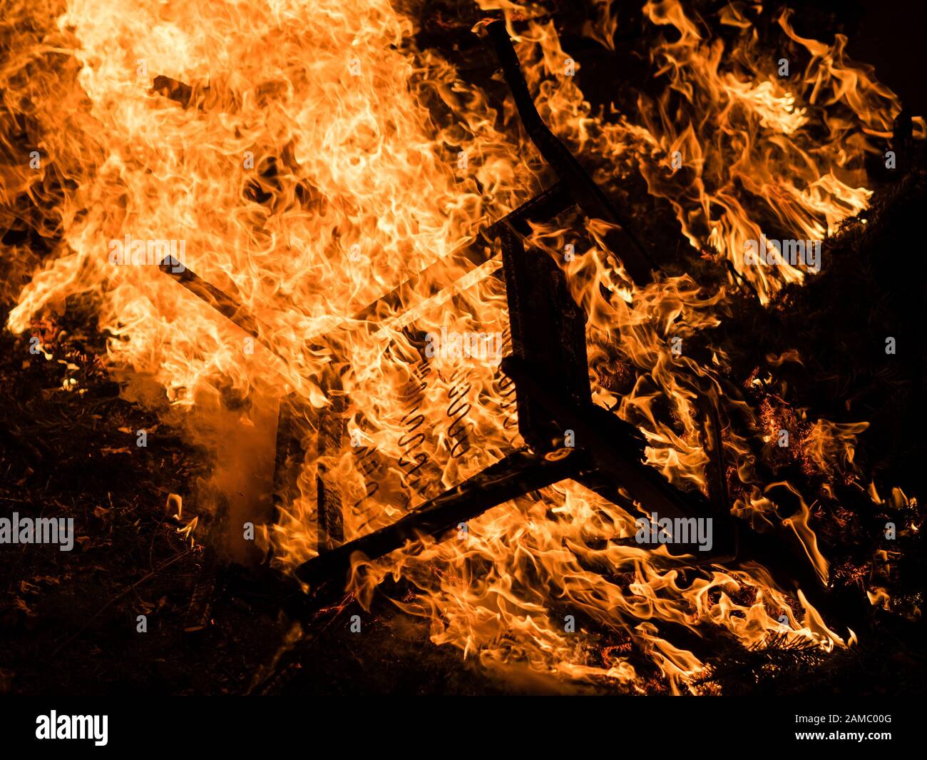 Overturned chair engulfed in flames Stock Photo