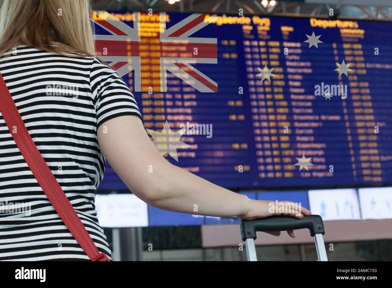 Woman looks at the scoreboard at the airport. Select a country Australia for travel or migration. Stock Photo