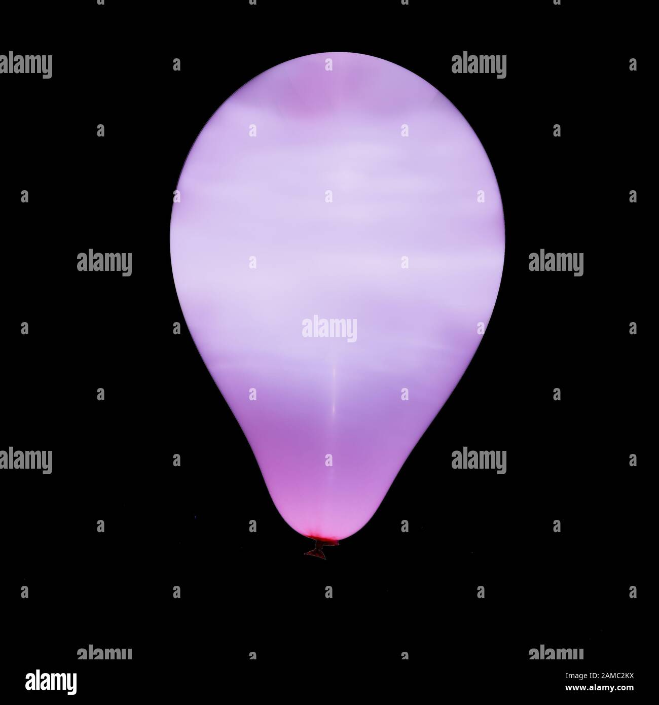 Purple balloon illuminated with intern LED light against dark background Stock Photo