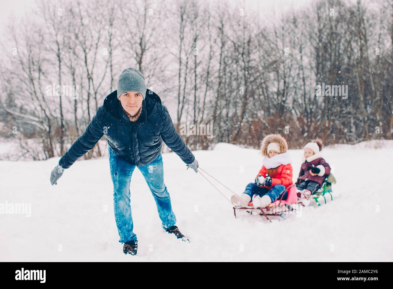 Infant Sleigh Riding Little kids enjoy a sleigh ride. Family sledding. Children play ...