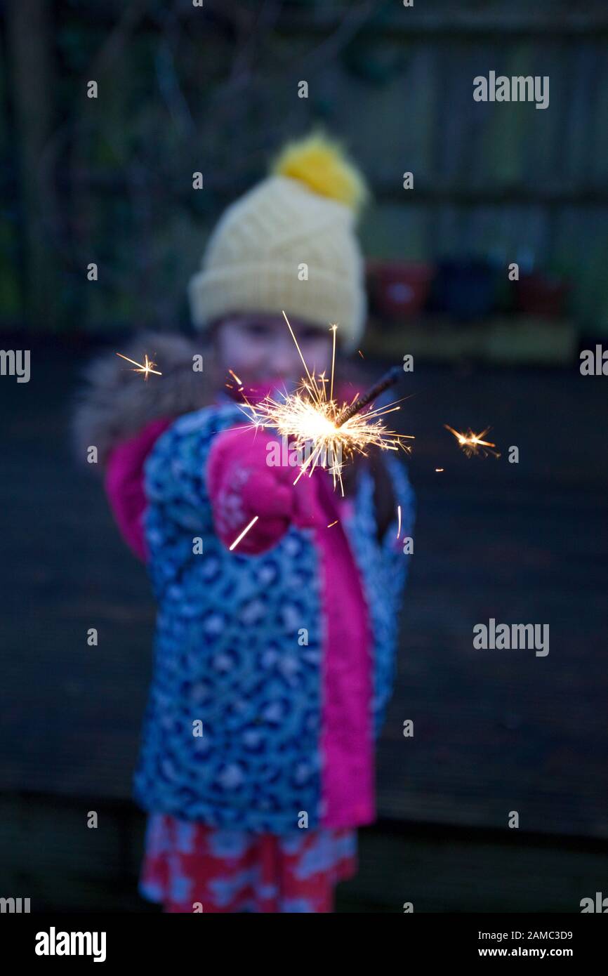 Young girl holding sparkler outside Stock Photo