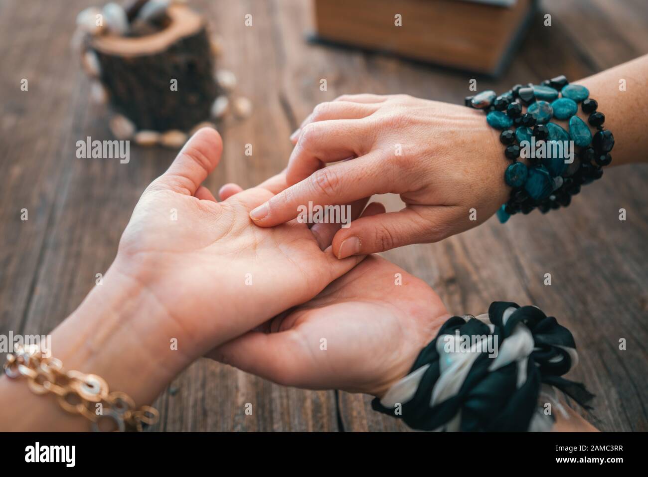 Close up of fortune teller point her finger to woman's palm line and read her fortune. Palmistry cpncept Stock Photo