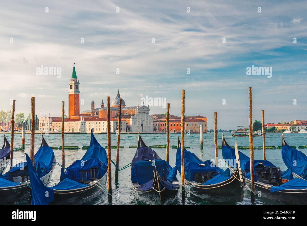 Gondolas moored by Saint Mark square with San Giorgio di Maggiore church on background in Venice, Italy during sunrise Stock Photo
