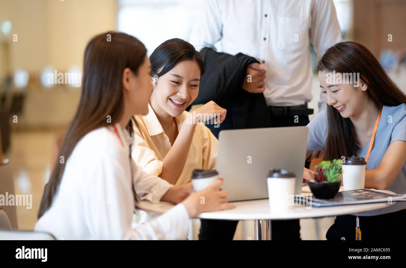 Happy young Asian business people discussing creative project Meeting Discussion with laptop in modern creative office discussion about online marketi Stock Photo