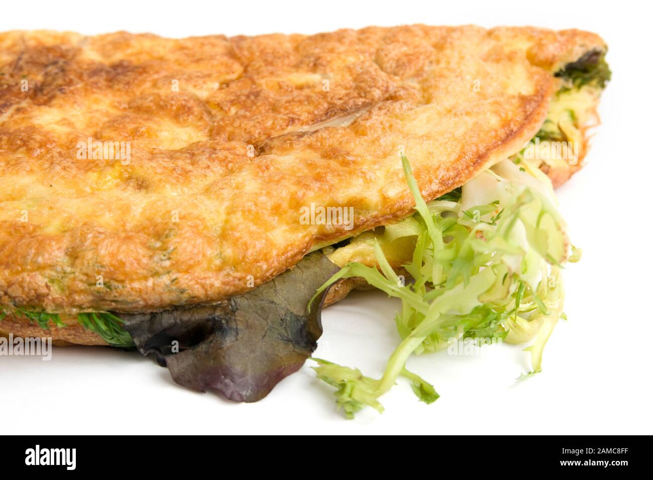 Single egg omelet,filled with fried onions, peppers, and lettuce, folded and ready to eat.  White background Stock Photo