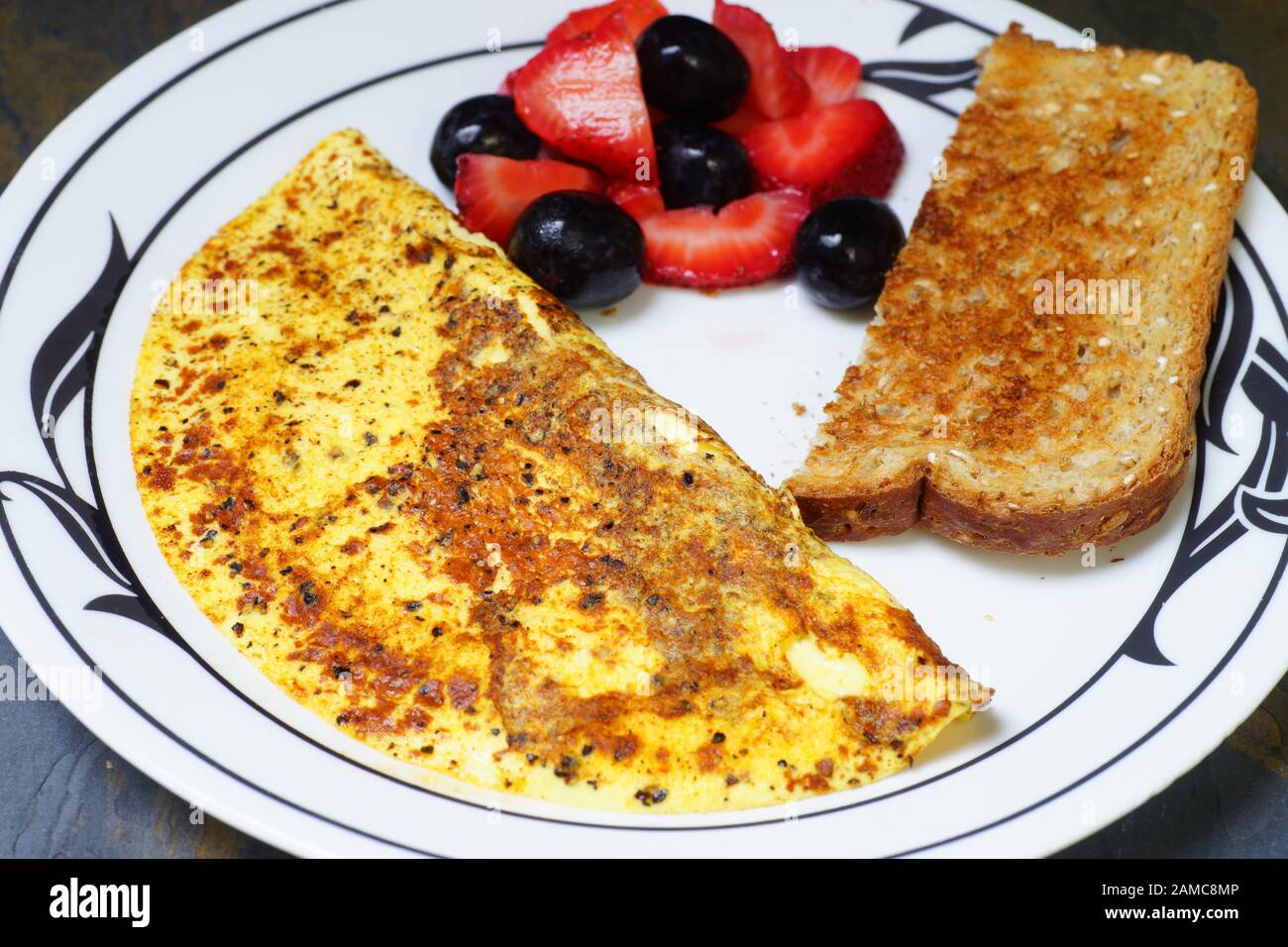 Healthy breakfast egg omelet with whole wheat toast and fruit Stock