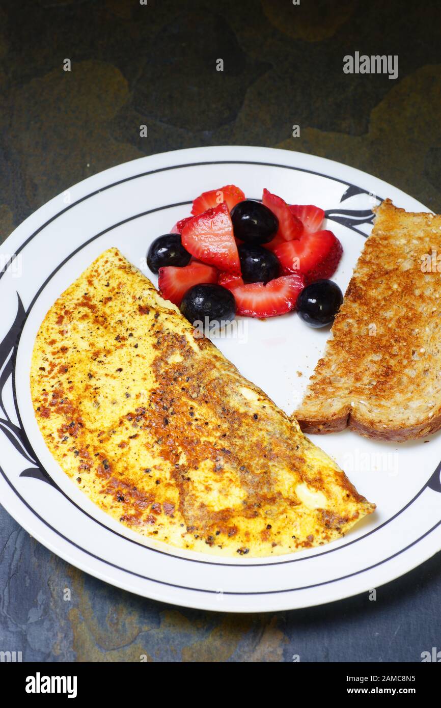 Healthy breakfast egg omelet with whole wheat toast and fruit Stock