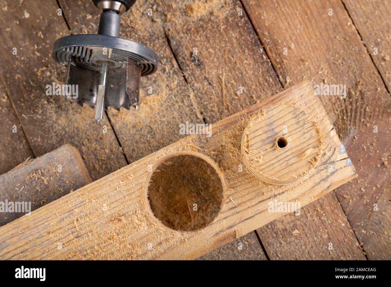 Wood hole saw and raw board. Making holes in raw wood. Place