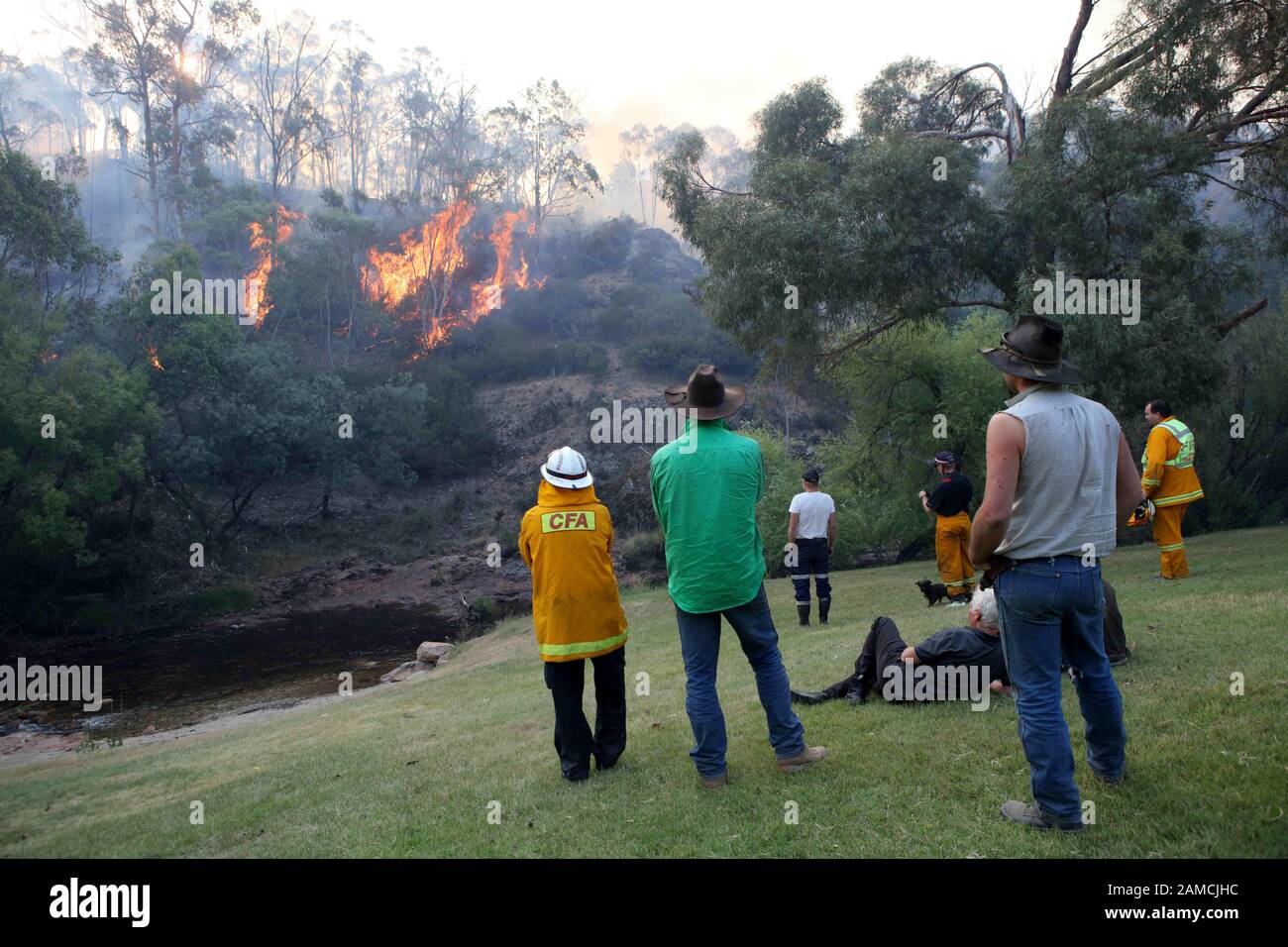 Victoria, Australia. 12th Jan, 2020. Firefighters from a joint Australian and U.S. strike team and locals watch as firefighters blackline an area on a nearby hillside in order to control a bushfire and protect nearby structures, in Alpine National Park near Omeo. The Australian firefighters are with Country Fire Authority Australia and the U.S. team is the third rotation in for 28 days and they come from five different U.S. agencies. Credit: ZUMA Press, Inc./Alamy Live News Stock Photo