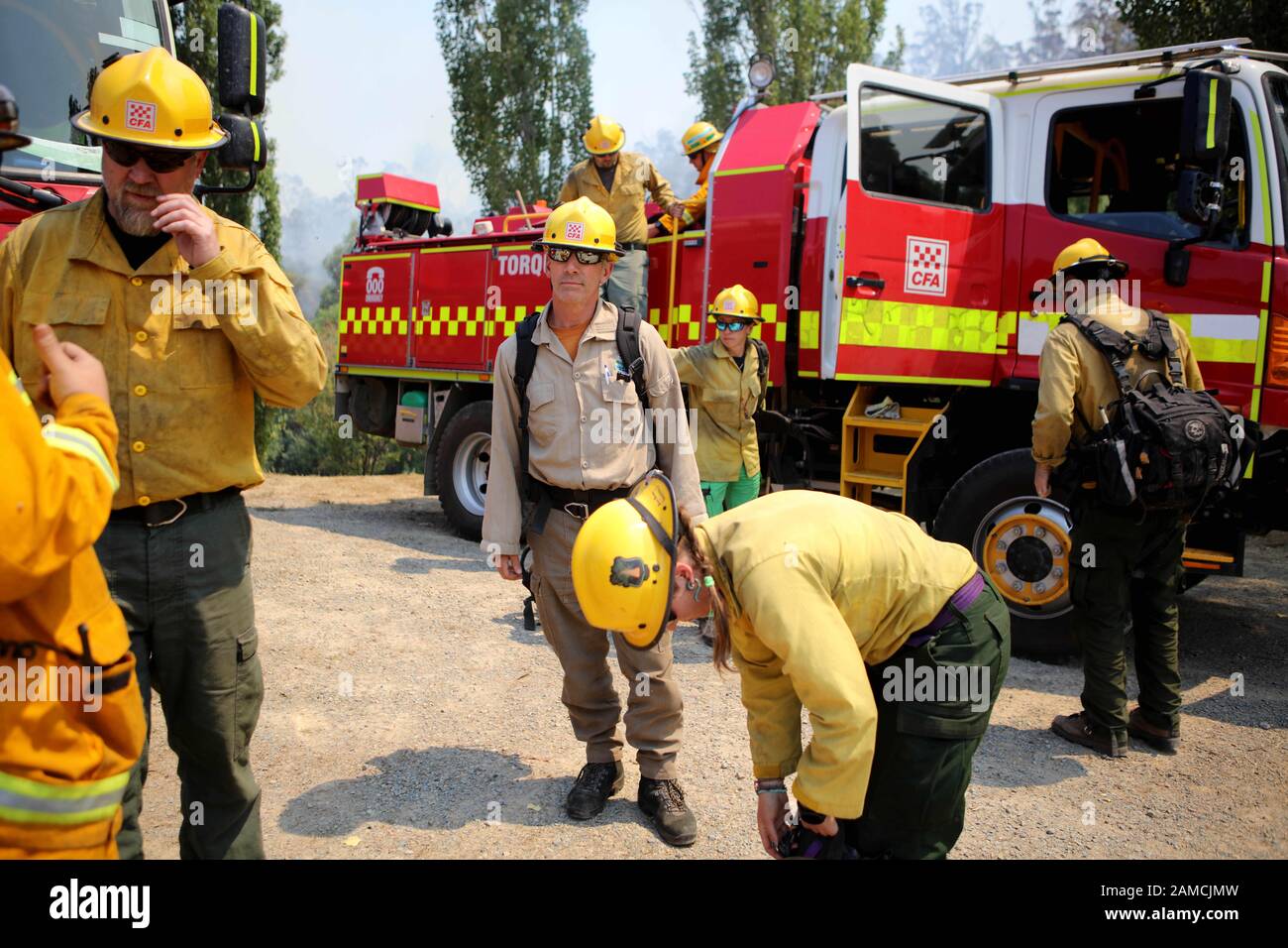 Victoria, Australia. 12th Jan, 2020. Firefighters from a joint Australian and U.S. strike team have a briefing as they work bring bushfire under control to protect nearby structures, in