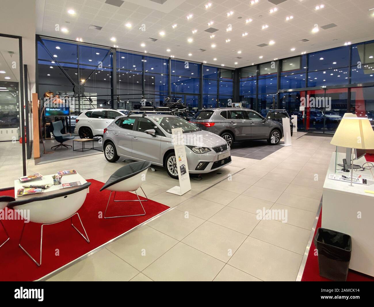 Paris, France - Oct 25, 2019: Wide angle view of empty car dealership showroom interior with multiple Seat Cars inside and focus on black Silver Ibiza four door model Stock Photo