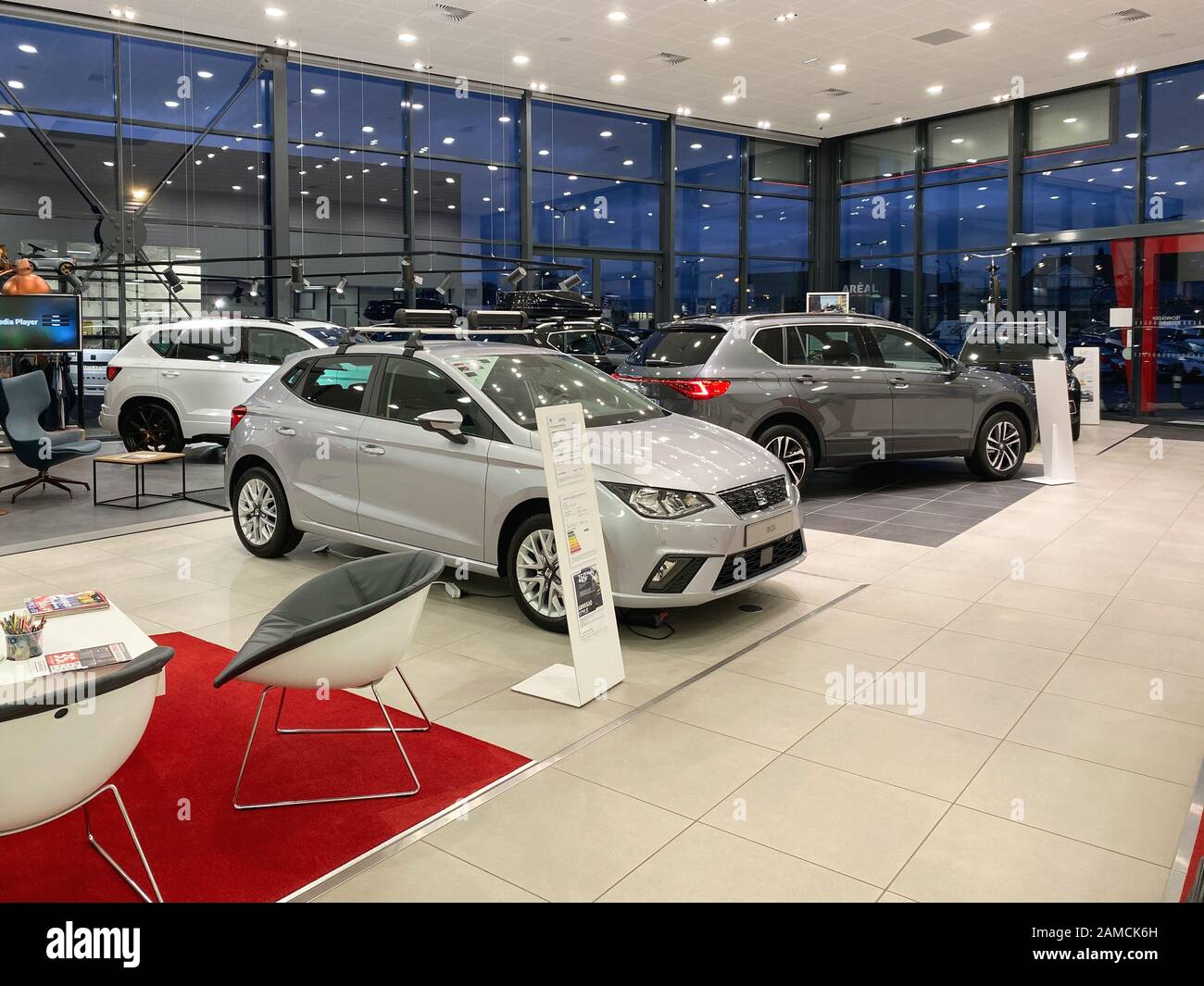 Paris, France - Oct 25, 2019: Wide angle view of empty car dealership showroom interior with multiple Seat Cars inside and focus on black Silver Ibiza four door model Stock Photo