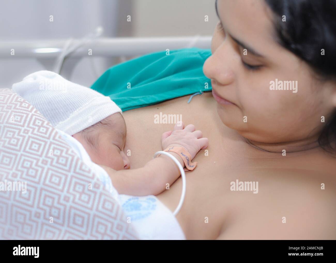 A young woman with her baby on her chest, at women's hospital.  Guayaquil.  Ecuador Stock Photo