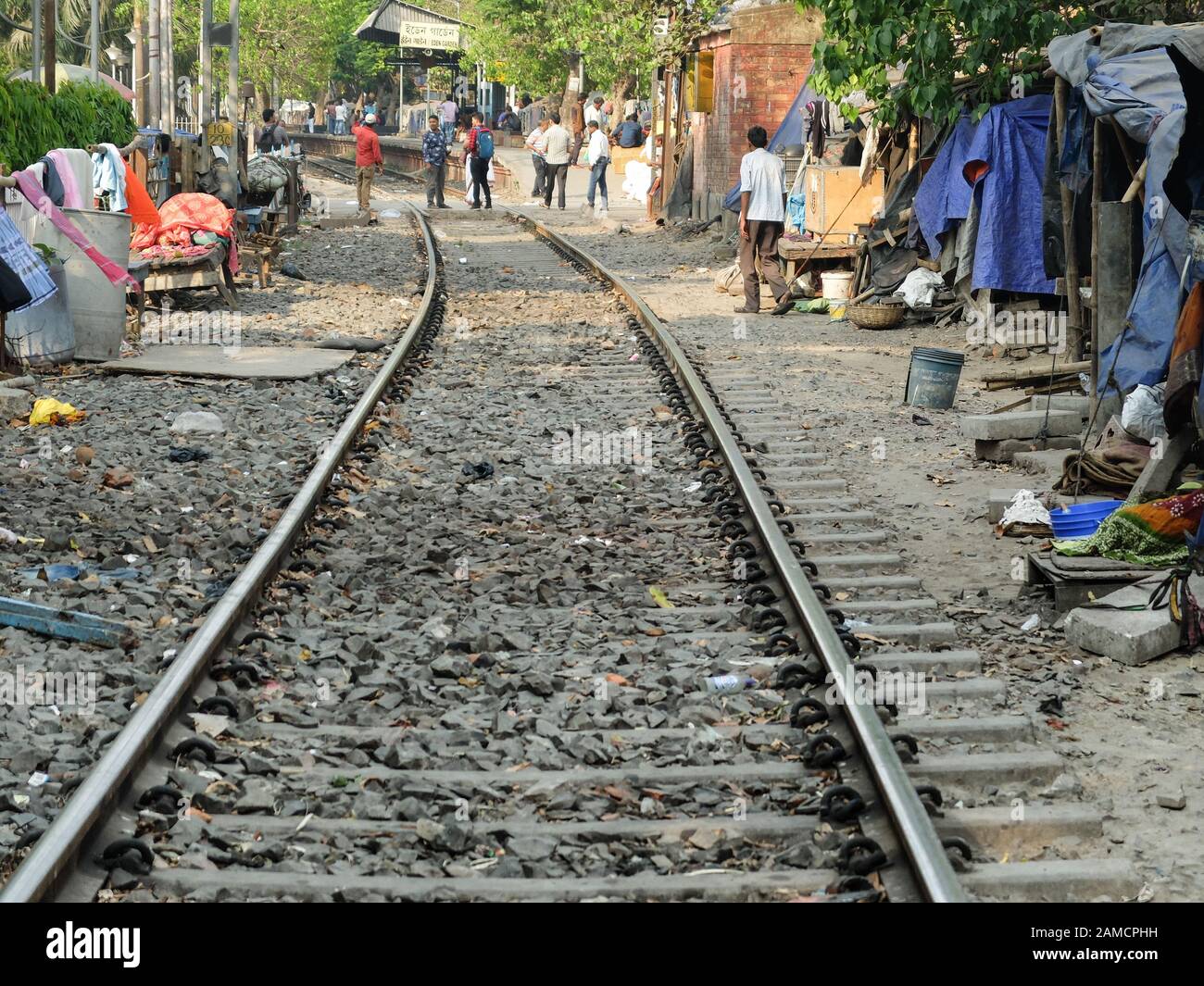 KOLKATA,WEST BENGAL/INDIA-MARCH 20 2018:Makeshift shanty dwellings provide shelter for the poor who live along the edges of the railway tracks in the Stock Photo