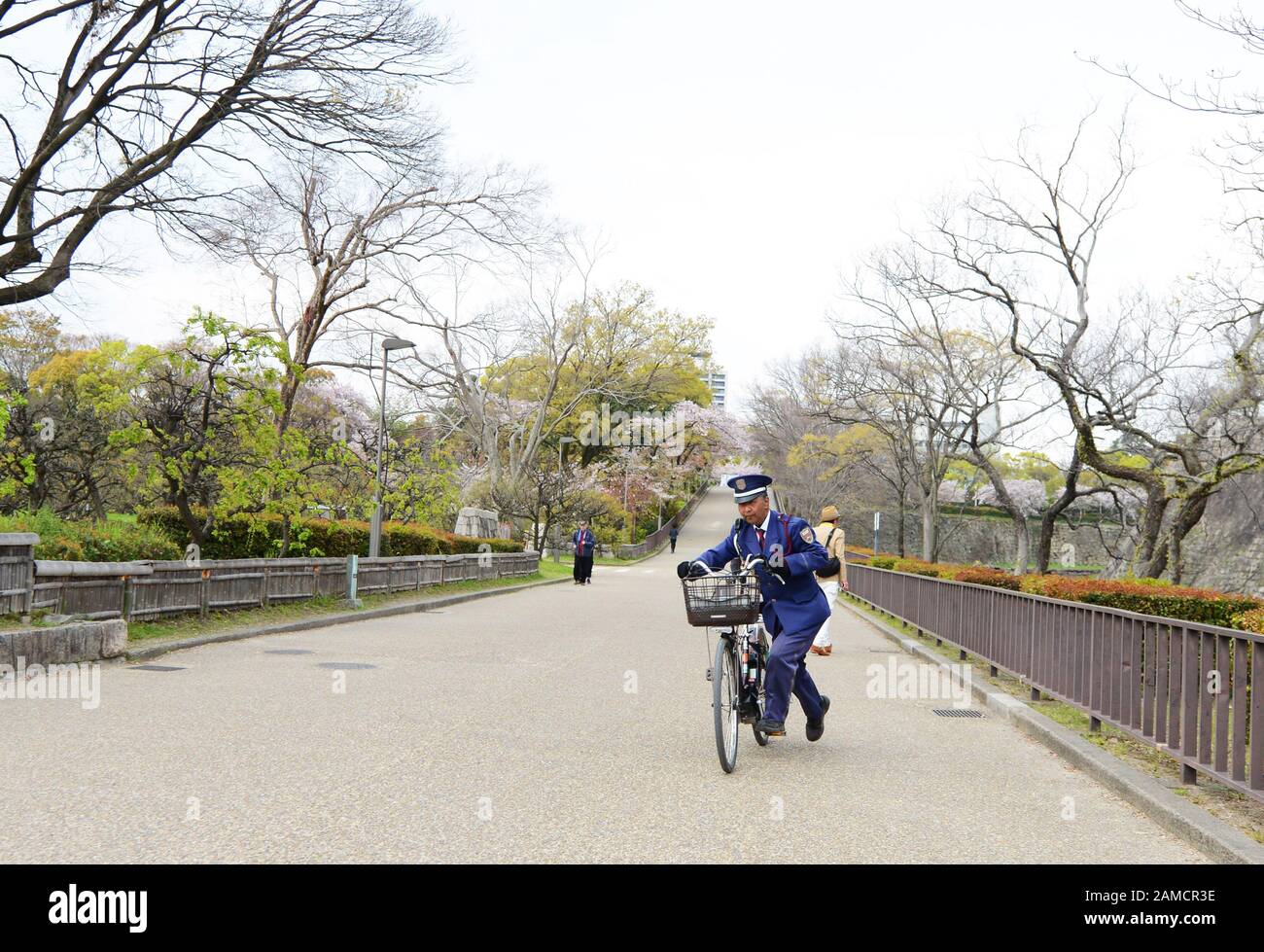 A Japanese policeman riding his cycle in the Osaka castle park. Stock Photo