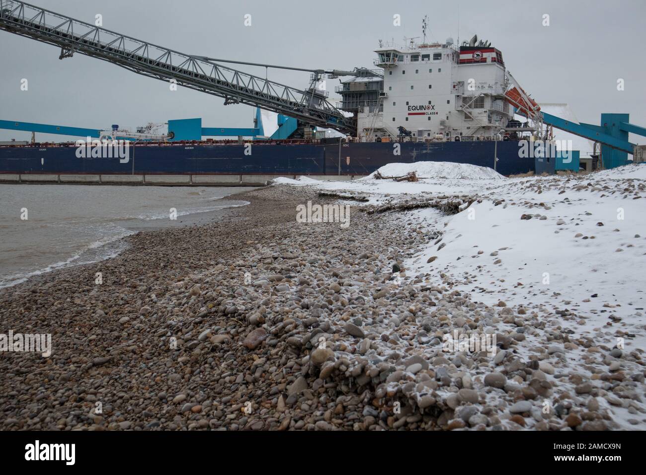 A view of the rocky and snowy beach of Goderich as well as part of a huge boat moored at the port loading and unloading facilities. Stock Photo