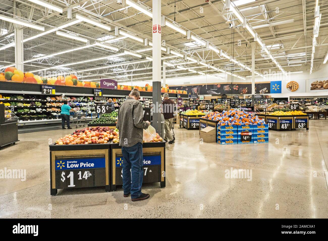 a Tucson Walmart produce section with tiered bins for bundled goods in dividing wall & huge open space with well spaced islands for picking from piles Stock Photo