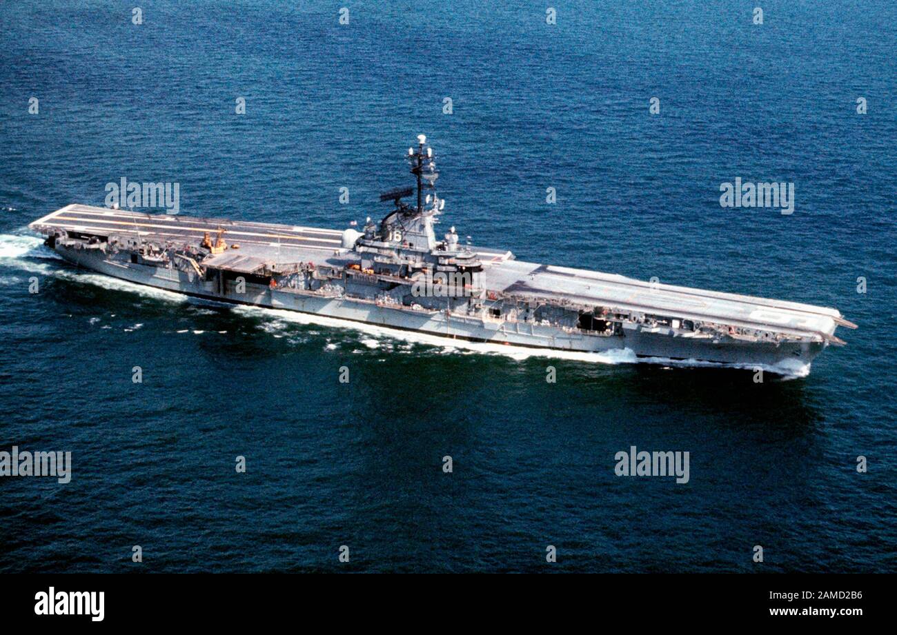 The U.S. Navy training aircraft carrier USS Lexington (CVS-16) underway. Note that the ship is still equipped with Mk 24 12.7 cm/38 open gun mounts that were removed in 1969. She also still carries her full radar complement (SPS-8A, SPS-12 and SPS-43) that was installed in 1961. Stock Photo