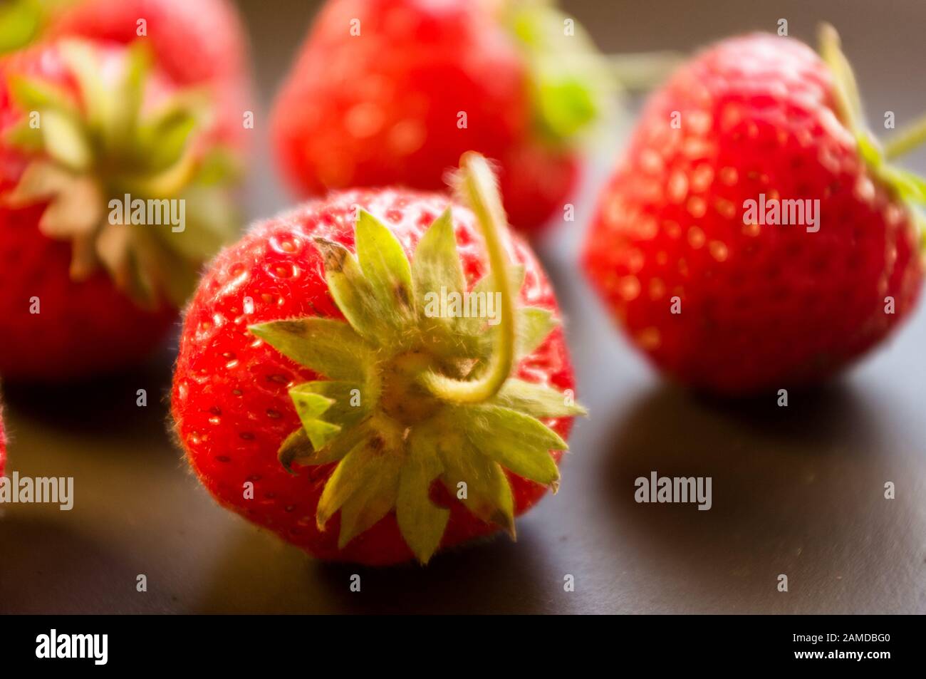 fresh ripe berries strawberries on black ceramic plate Stock Photo - Alamy