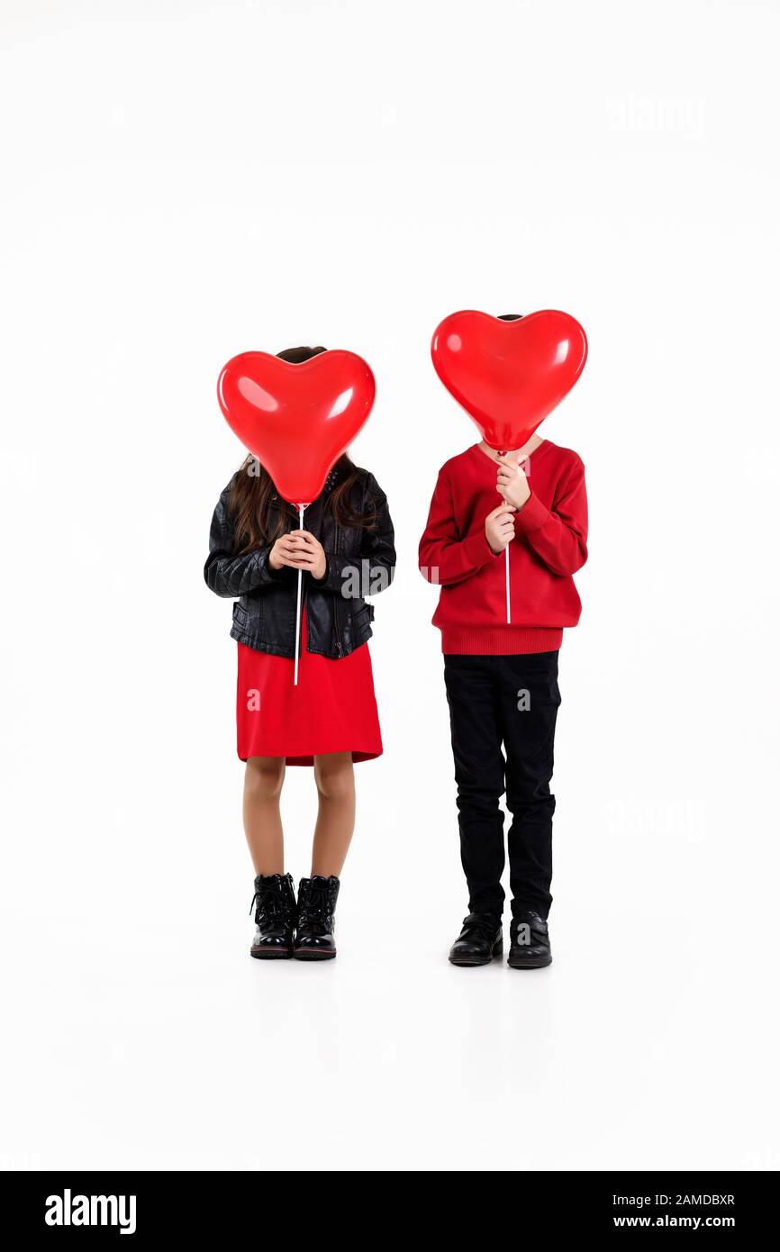 couple child girl and boy holding red heart balloons isolated on white ...