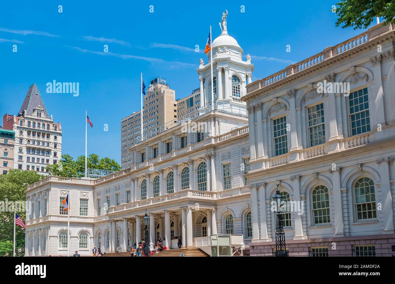 New York - June 2, 2016: Facade of the City Hall and Manhattan Municipal Building in lower Manhattan with people on the steps Stock Photo