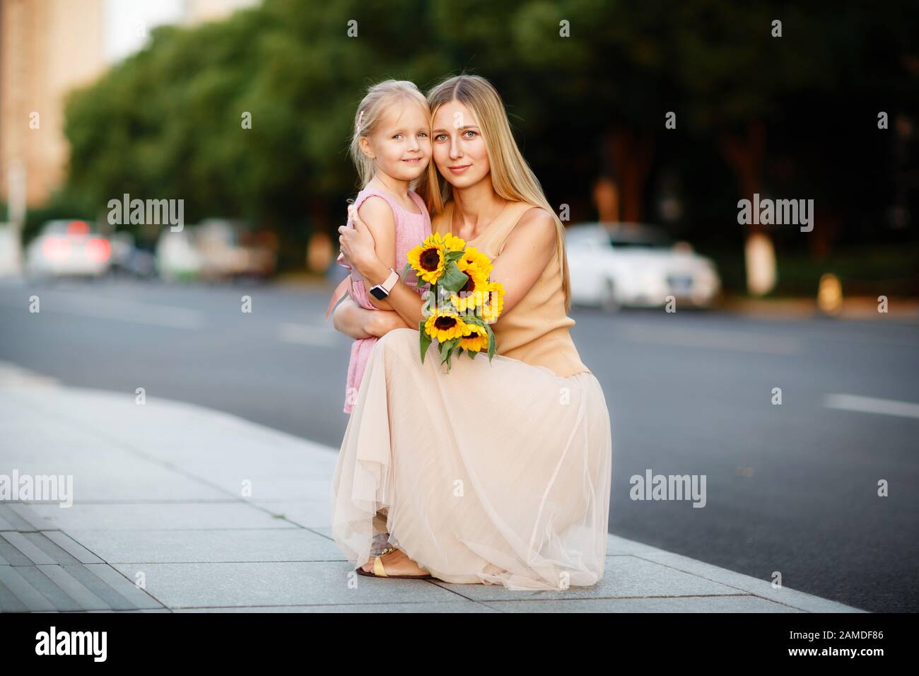 Portrait of beautiful woman and girl with sunflowers Stock Photo - Alamy