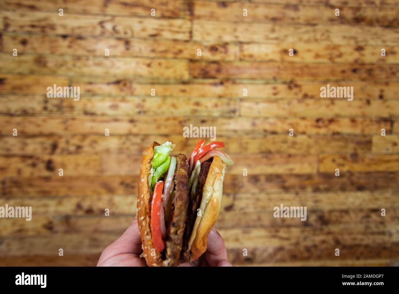 man's hands, holding onto a burger Stock Photo
