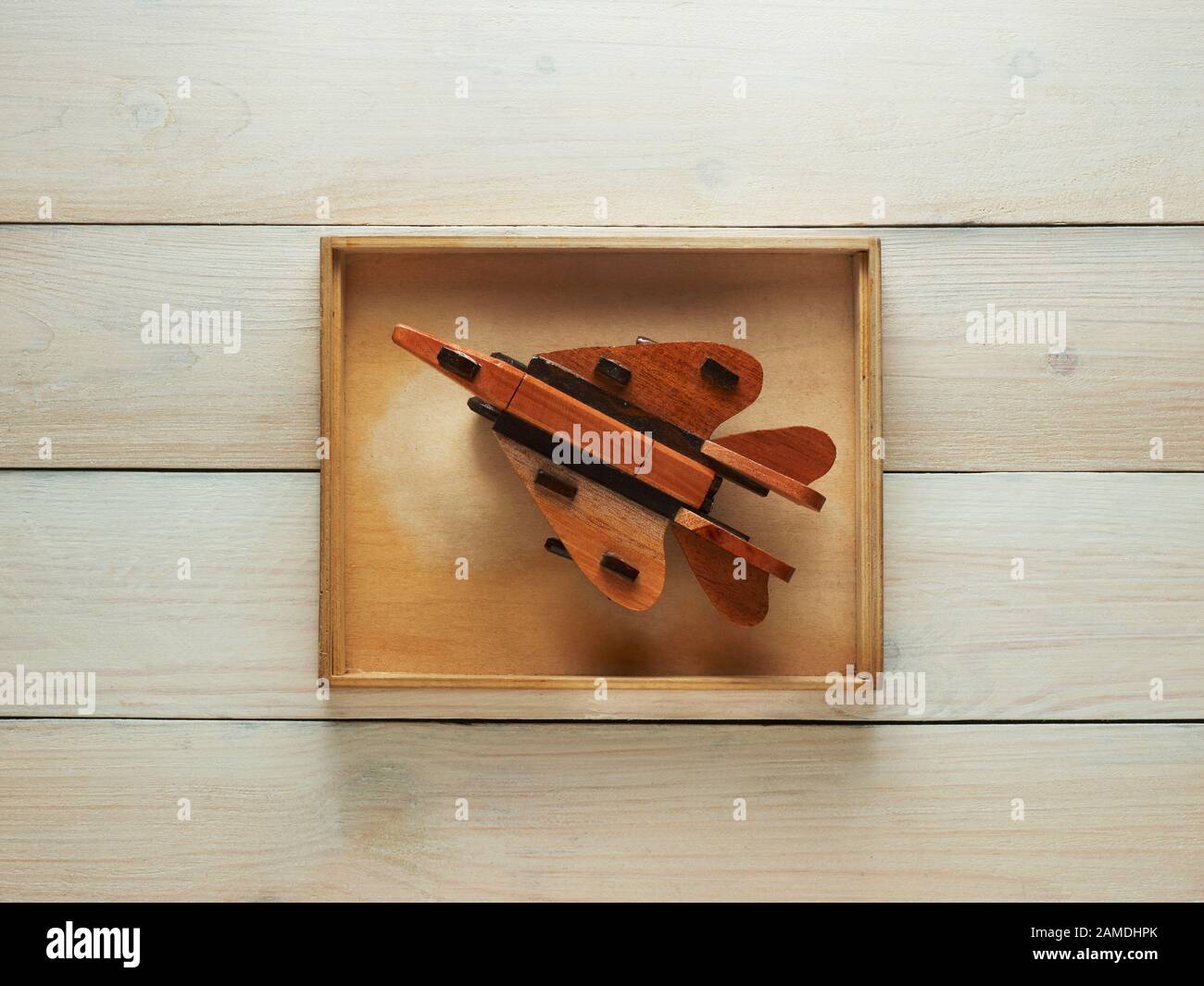 Wooden toy jet plane in a wooden box with a wooden background Stock Photo