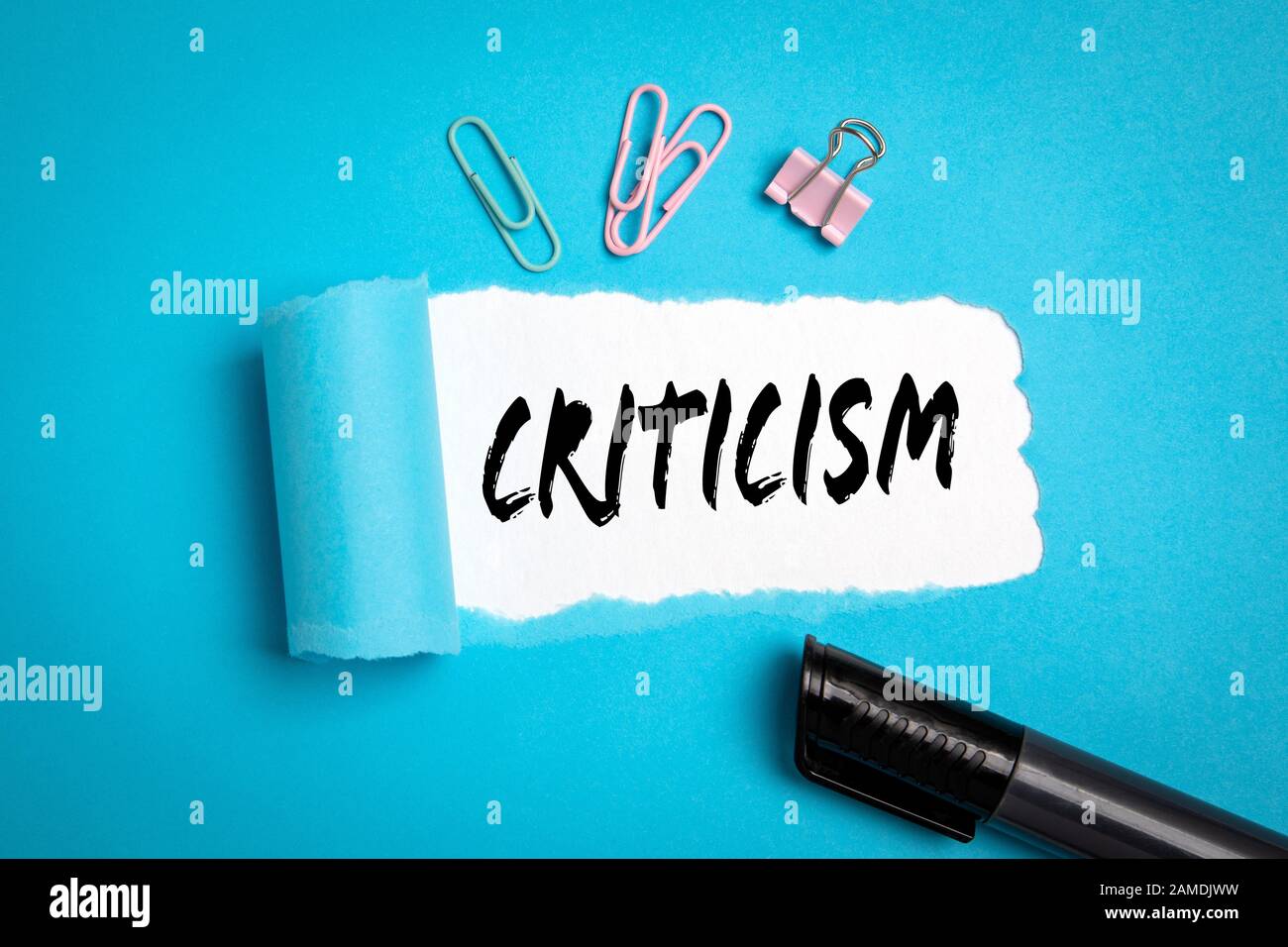 Criticism. Diversity of views, beliefs, thoughts and disagreements concept. Text under torn paper Stock Photo