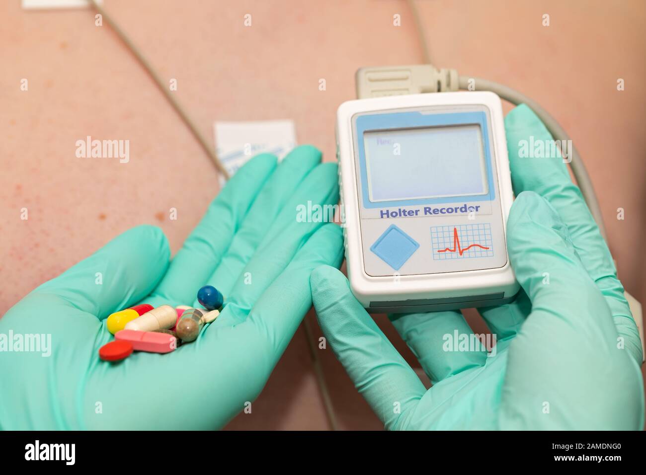 Doctor's hand applying holter heart monitor on young man's chest Stock Photo