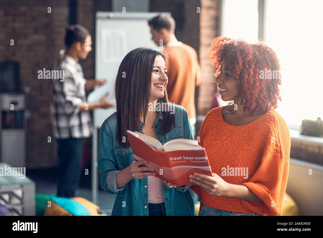 Mulatto student smiling while standing near best friend Stock Photo