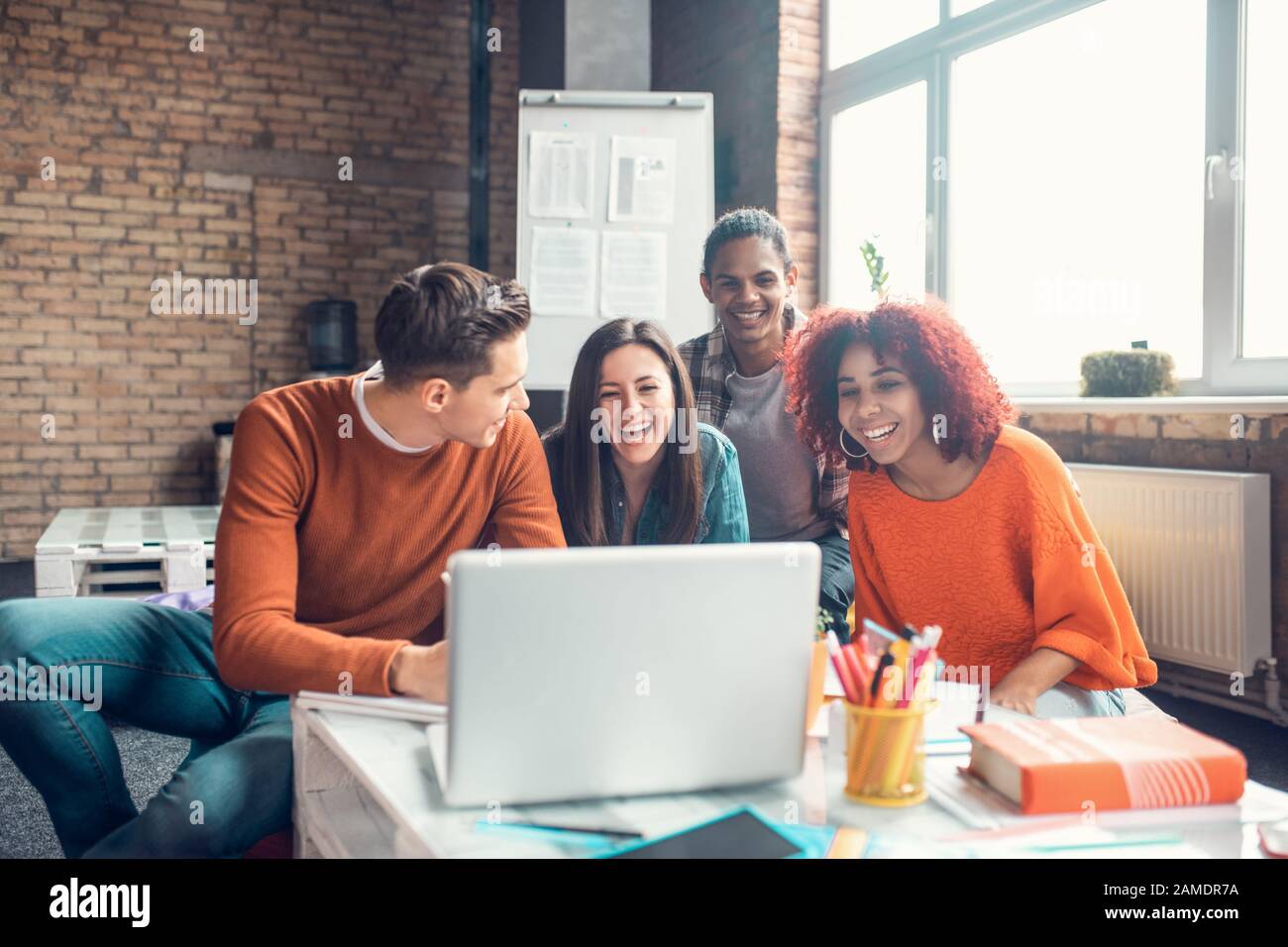 Students laughing while having little break and watching funny video Stock Photo
