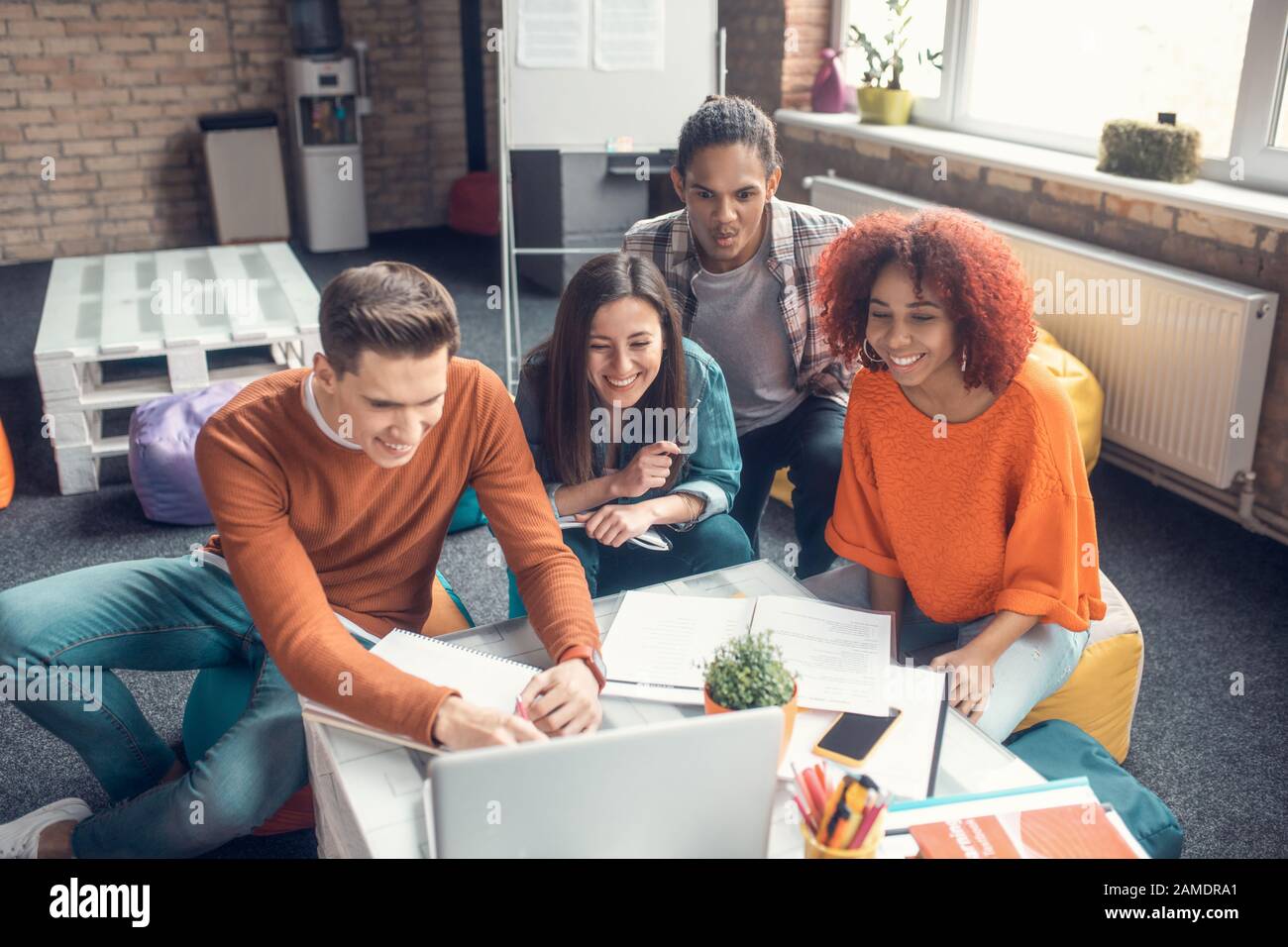 Top view of students making notes while watching webinar together Stock Photo