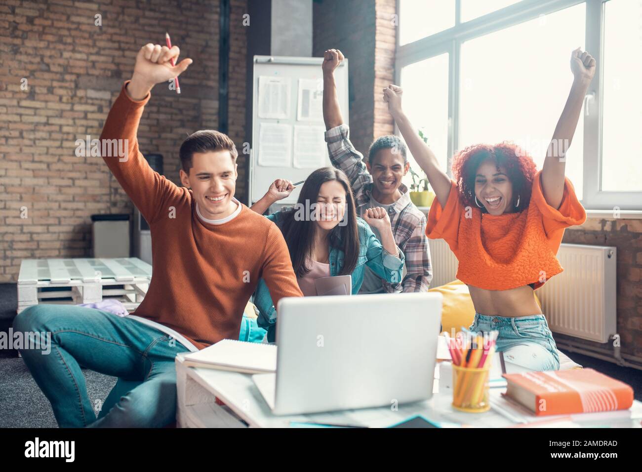 Cheerful students feeling happy while watching webinar together Stock Photo
